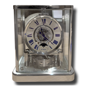 Pendule de table sous cube en verre, cadran à chiffres romains bleus et mécanisme apparent