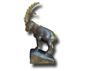 Sculpture en bronze représentant un bouquetin debout, grandes cornes recourbées, sur un socle rocheux