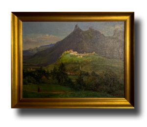 Tableau encadré : paysage de montagne avec sommet rocheux, village sur une colline verdoyante et arbres au premier plan