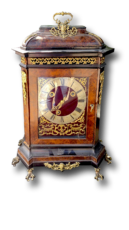 Pendule de table ancienne décorée, boîtier sombre avec ornements dorés, cadran rond, posée sur quatre pieds