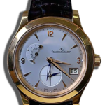 Montre de luxe vintage en or jaune, cadran blanc.