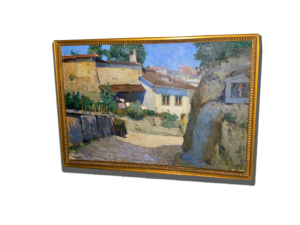 Tableau encadré représentant une ruelle de village ensoleillée avec maisons en pierre, muret et grand arbre au premier plan
