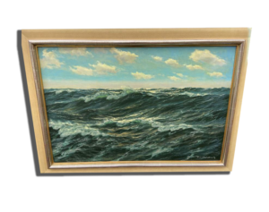 Tableau encadré : voilier au premier plan sur une mer agitée, horizon lumineux et ciel gris, ambiance maritime