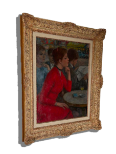 Tableau encadré dans un cadre doré ornementé représentant une scène de café avec une femme en robe rouge assise de profil, la main sous le menton, près d’une table ronde, avec un homme en train de lire et d’autres figures en arrière-plan. Tableau, peinture figurative, art, antiquités