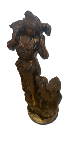 Sculpture en bronze figurative représentant une femme ailée debout, tête baissée et bras relevés, avec drapés et textures sculptées, posée sur une base rocailleuse avec un petit animal type agneau sur le côté. Sculpture en bronze, statue, art, antiquités, Valais,