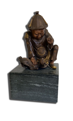 Statuette en bronze polychrome d’inspiration asiatique : personnage accroupi avec chapeau conique accompagné d'un animal, sur socle en pierre