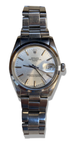 Montre suisse vintage avec cadran argent, index bâtons et bracelet acier.