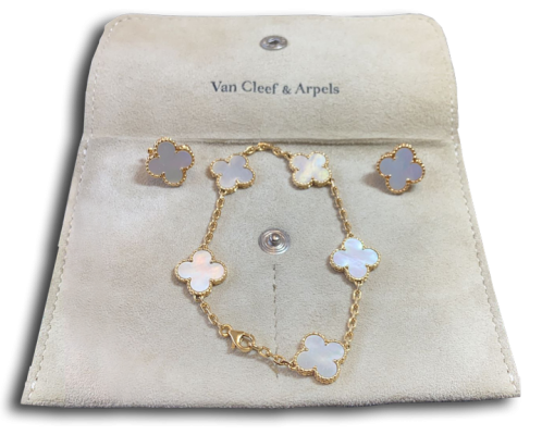 Ensemble de bijoux de luxe avec bracelet en chaîne dorée et motifs trèfle en nacre, accompagné de deux boucles d’oreilles assorties, présenté sur un étui clair. Bijoux, bracelet, joaillerie, or, nacre, antiquités, Valais, antiquaire,