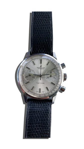 Montre vintage de luxe type chronographe avec cadran argenté, deux compteurs et bracelet en cuir bleu texturé ;