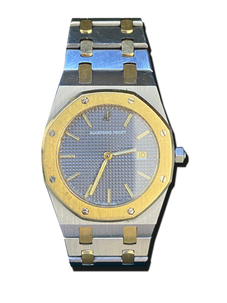 Montre vintage de luxe bicolore acier et or avec bracelet intégré, lunette octogonale vissée et cadran bleu texturé, affichage date