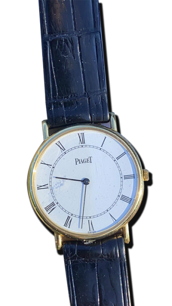 Montre vintage de luxe au style classique : boîtier doré fin, cadran blanc à chiffres romains et bracelet en cuir noir embossé ; Suisse, Valais, achat antiquaire