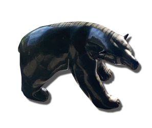 Sculpture d’ours en pierre noire polie, silhouette massive en marche avec finition brillante sur fond sombre.