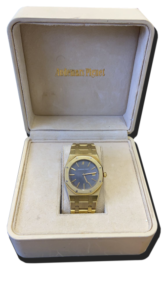 Montre de collection en métal doré avec bracelet intégré, cadran bleu texturé et lunette octogonale, présentée dans un écrin – achat et estimations montres