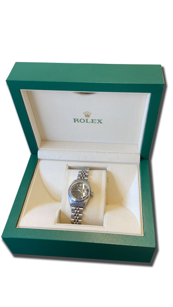 Montre de collection (montre vintage suisse) sur bracelet acier à maillons, cadran sombre, présentée dans un écrin vert