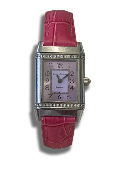 Montre vintage suisse de luxe à boîtier rectangulaire en métal argenté, cadran clair à chiffres arabes, sertissage de petites pierres sur la partie haute et basse, bracelet cuir rouge.