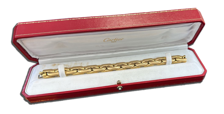 Bijoux en or cartier de luxe présentés avec détails des formes et des surfaces métalliques. Achat bijoux or luxe, Suisse, Valais,