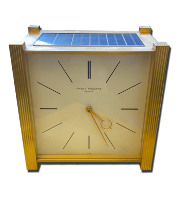 Horloge de table rectangulaire vintage de luxe, cadran clair minimaliste, flancs dorés cannelés et panneau supérieur type solaire.